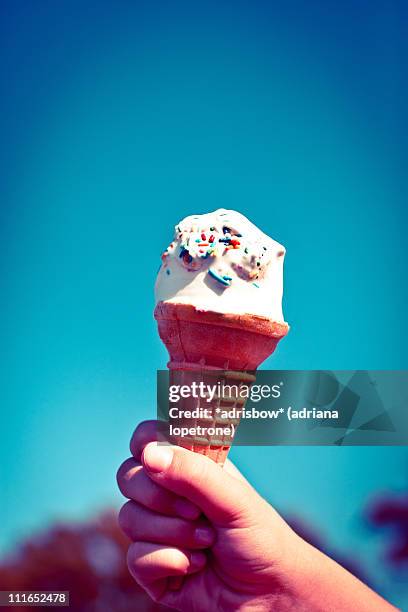 child holding ice cream cone with sprinkles - ice cream sprinkles stock pictures, royalty-free photos & images