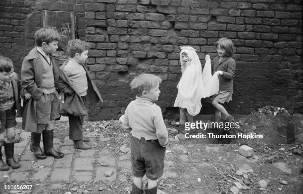 Group of children playing in a slum area of Liverpool, 19th November 1956. One of the girls is wearing a wedding headdress. Original publication:...
