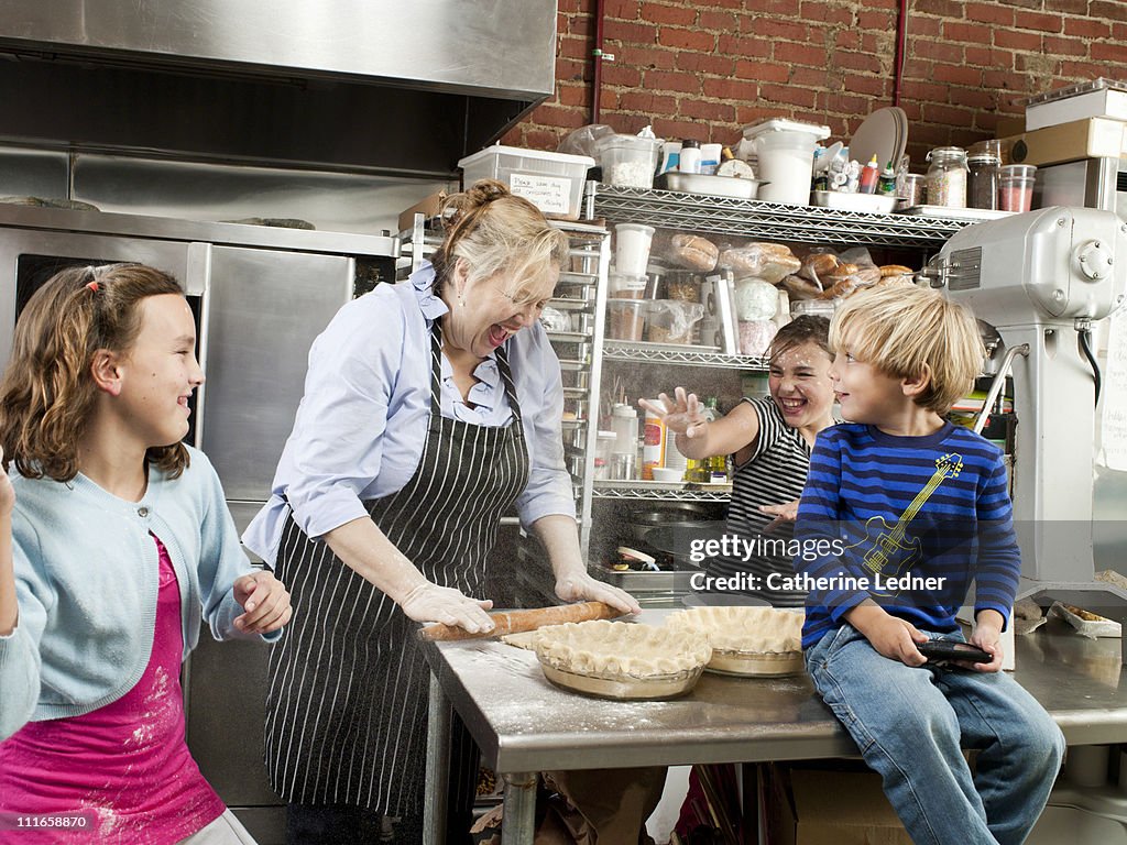 Kids playing with mother in family-owned bakery