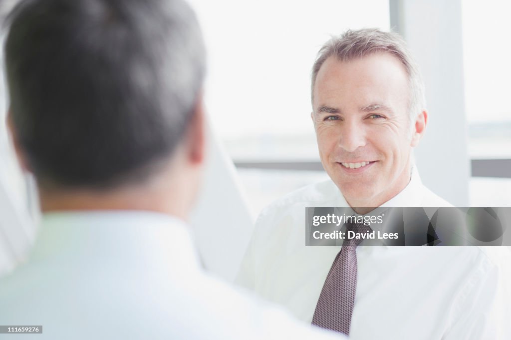 Businessmen in meeting, smiling