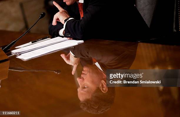 Secretary of the Treasury Timothy F. Geithner, seen in a reflection in a table, speaks during a hearing of the Senate Appropriations Committee...