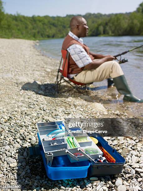 black man with tackle box fishing in stream - fishing tackle box stockfoto's en -beelden