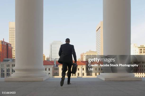 african american businessman running from courthouse - government spending stock pictures, royalty-free photos & images