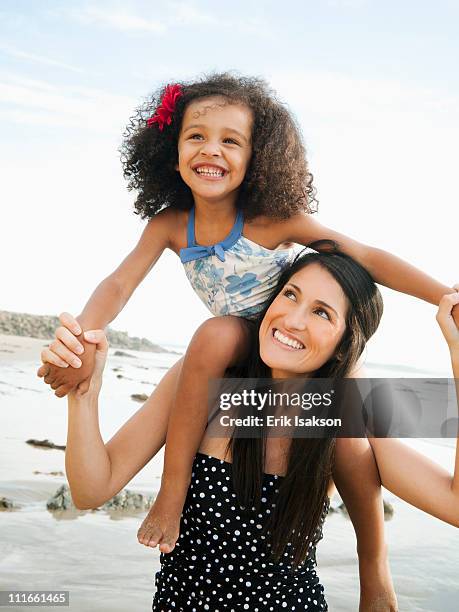 hispanic mother carrying daughter on shoulders at beach - hot latino girl imagens e fotografias de stock