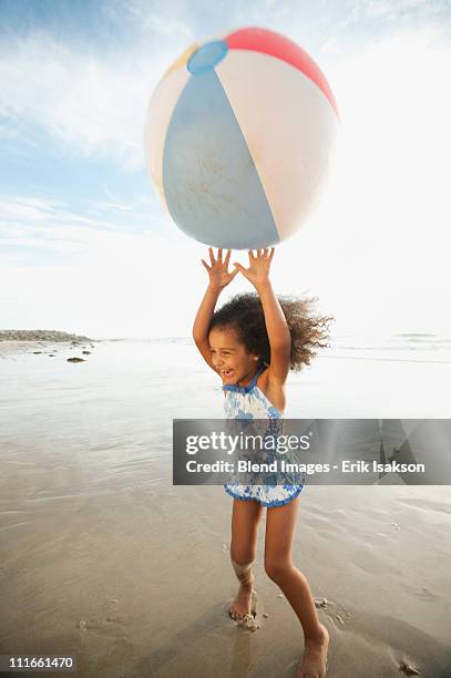 mixed race girl playing with large ball on beach - large beach ball stock pictures, royalty-free photos & images
