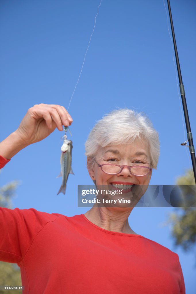 Mixed race woman catching small fish
