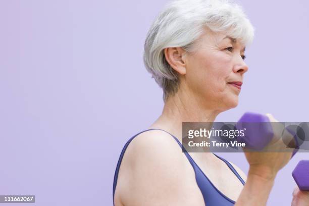 mixed race woman exercising with dumbbells - asian female bodybuilder stock-fotos und bilder