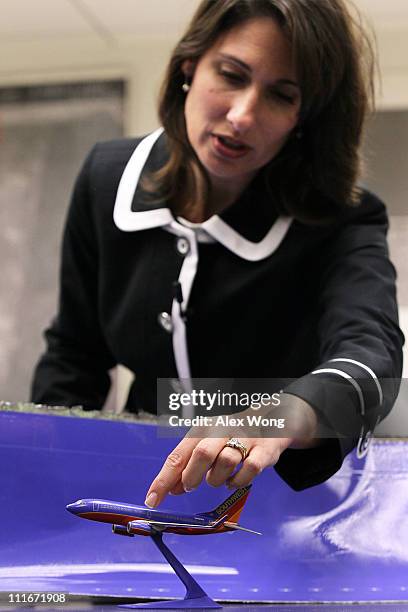 National Transportation Safety Board Chairman Deborah Hersman points out on a model Southwest Airlines plane the position where the fuselage skin was...