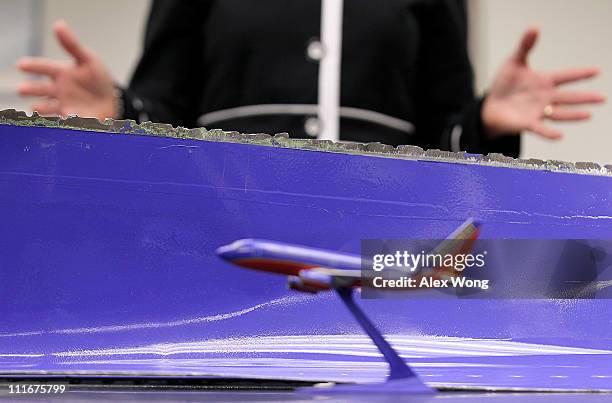 National Transportation Safety Board Chairman Deborah Hersman points out on a model Southwest Airlines plane the position where the fuselage skin was...