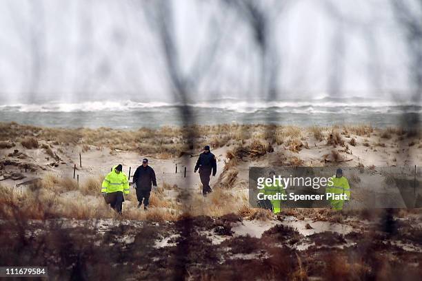 Suffolk County Police and police recruits search an area of beach near where police recently found human remains on April 5, 2011 in Babylon, New...