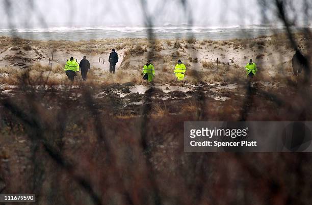 Suffolk County Police and police recruits search an area of beach near where police recently found human remains on April 5, 2011 in Babylon, New...