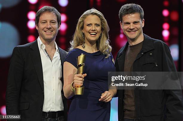 German television presenter Barbara Schoeneberger poses with the Lola German film award and director Florian Gallenberger and producer Benjamin...