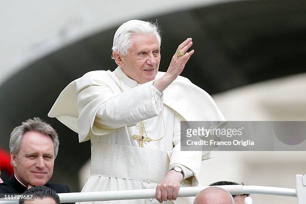 Pope Benedict XVI, flanked by his personal secretary Monsignor Georg Gaenswein, waves to the faithful gathered in St. Peter's Square during his...