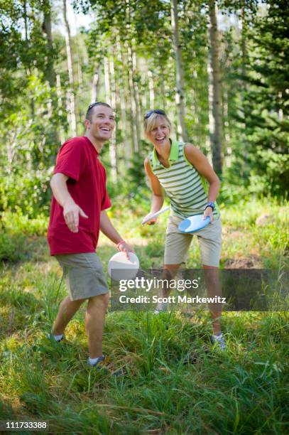 man and woman playing disc golf, park city, utah. - disc golf stock-fotos und bilder