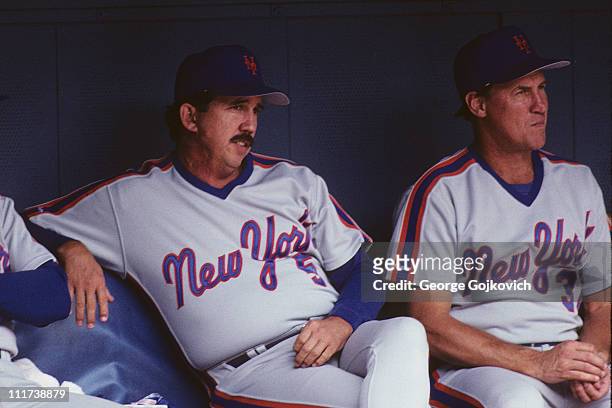 Manager Davey Johnson of the New York Mets sits in the dugout next to pitching coach Mel Stottlemyre during a game against the Pittsburgh Pirates at...