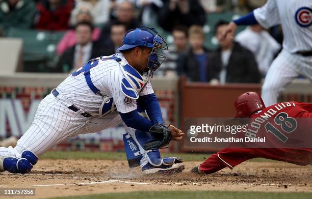 Geovany Soto of the Chicago Cubs drops the ball for an error as Willie Bloomquist of the Arizona Diamondbacks slides in to score in the 5th inning at...