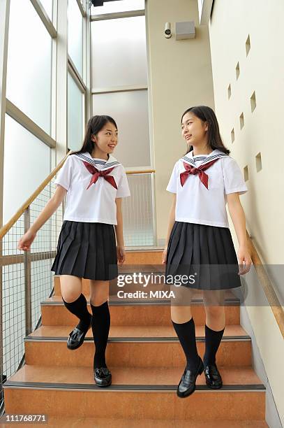 high school girls climbing down stairs - 制服 ストックフォトと画像