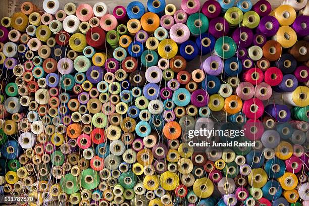 colorful stack  of pakistan's cotton thread reels - textile industry stock-fotos und bilder