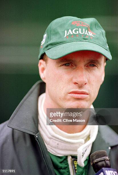 Eddie Irvine of Jaguar and Northern Ireland talks to the media during second timed practice for the Formula One British Grand Prix at Silverstone,...