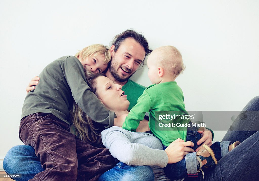 Young boy and a baby hugging dad and mother