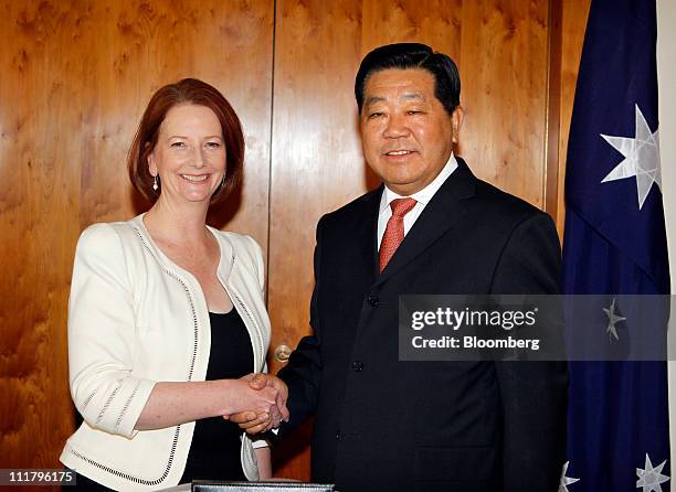 Julia Gillard, Australia's prime minister, left, shakes hands with Jia Qinglin, chairman of the Chinese People's Political Consultative Conference ,...