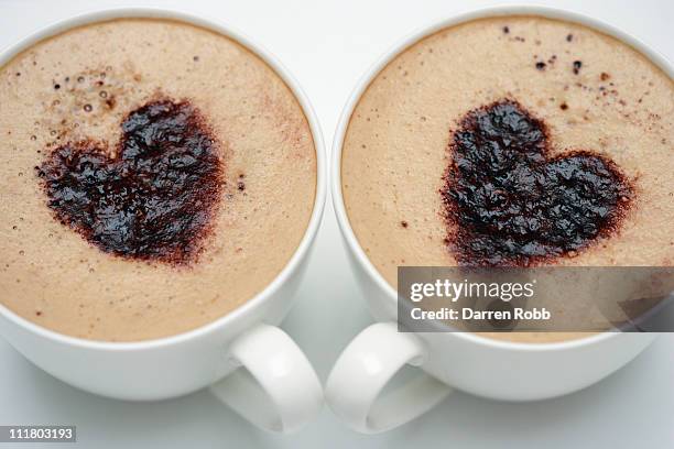 two cups of cappuccino with love heart decoration - coffee heart fotografías e imágenes de stock