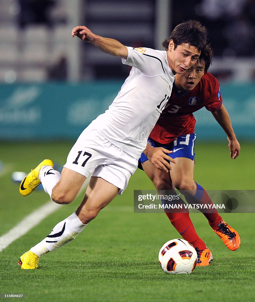 Uzbekistan's forward Sanjar Tursunov (L)
