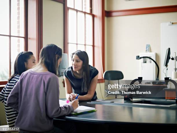 teacher working with two students in classroom - alert 3 stock pictures, royalty-free photos & images