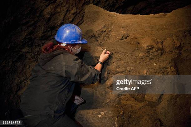 An archaeologist works inside a tunnel found under the ruins of the Feathered Serpent temple at the archaeological site of Teotihuacan, 45 km...