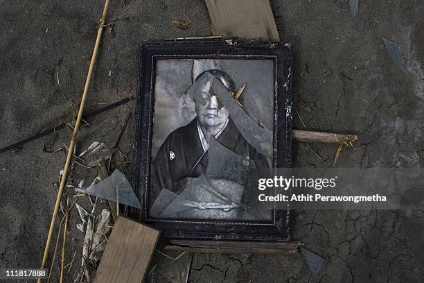 Broken picture frame lies in the mud within the exclusion zone, about 12 miles away from Fukushima Nuclear Power Planton April 7, 2011 in Minamisoma,...