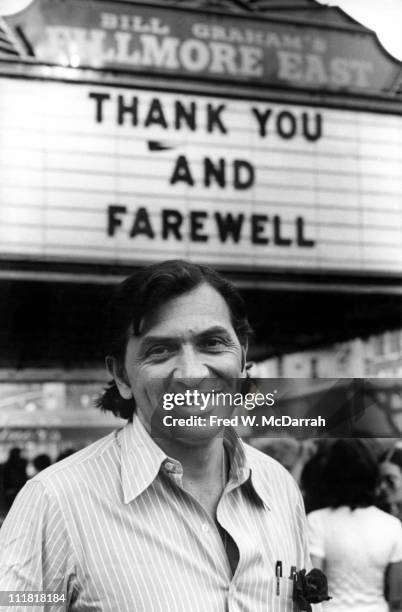 Portrait of German-born America concert promoter Bill Graham as smiles and poses under the marquee of his concert venue, the Fillmore East, on it's...