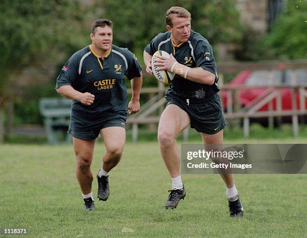 Andre Venter of South Africa charges with the ball while Ollie Le Roux watches on during Springbok training at Bishops Boys School in Cape Town South...