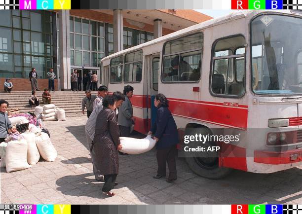 Ethnic Korean women living in China load sacks of maize 03 May in Tumen, China to take to their starving relatives in North Korea. A Red Cross...