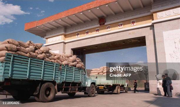 North Korean trucks loaded with sacks of maize wait for clearance 06 May at the Chinese border to cross the Tumen River into the city of Namyang in...