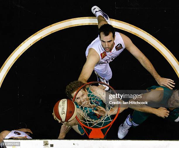 Luke Schenscher of the Crocodiles makes a layup past Ian Crosswhite of the Taipans during game one of the NBL Semi Final Series between the...