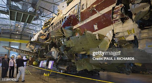 National Transportation Safety Board Chairman Mark V. Rosenker and US Secretary of Transportation Mary E. Peters are shown the re-assembled shell of...