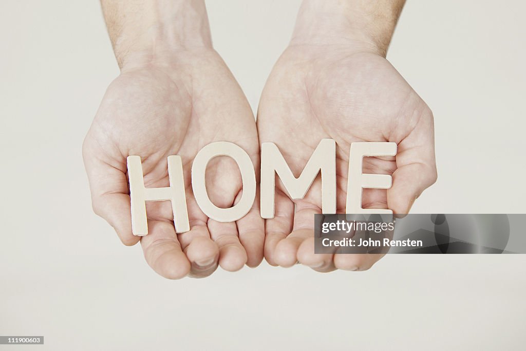 Hands holding letters spelling words