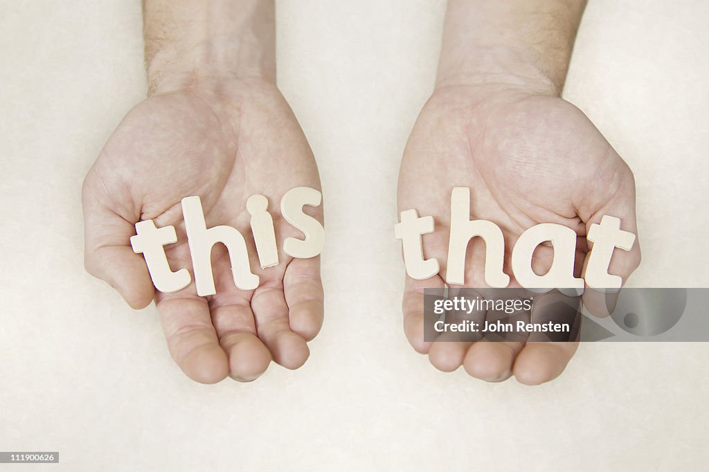 Hands holding wooden letters spelling words