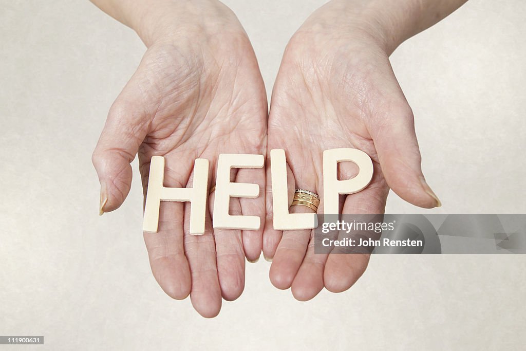 Hands holding wooden letters spelling words