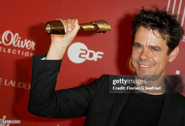 Director Tom Tykwer poses with his award during the 'Lola - German Film Award 2011' at Friedrichstadtpalast on April 8, 2011 in Berlin, Germany.