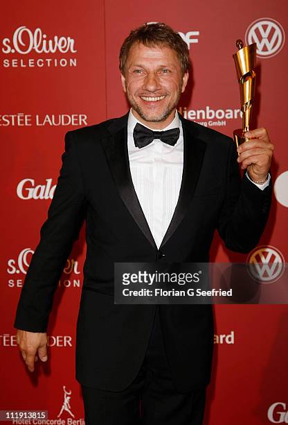 Richy Mueller poses with his award for Best Supporting Actor during the 'Lola - German Film Award 2011' at Friedrichstadtpalast on April 8, 2011 in...