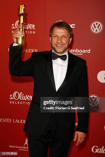 Richy Mueller poses with his award for Best Supporting Actor during the 'Lola - German Film Award 2011' at Friedrichstadtpalast on April 8, 2011 in...