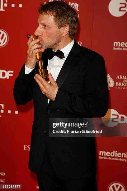 Richy Mueller poses with his award for Best Supporting Actor during the 'Lola - German Film Award 2011' at Friedrichstadtpalast on April 8, 2011 in...