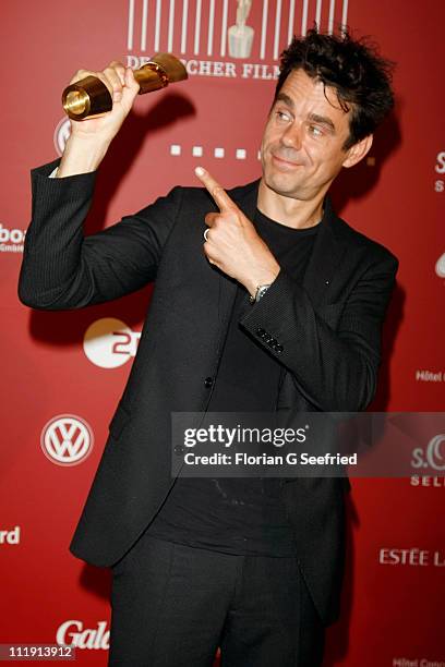 Director Tom Tykwer poses with his award during the 'Lola - German Film Award 2011' at Friedrichstadtpalast on April 8, 2011 in Berlin, Germany.