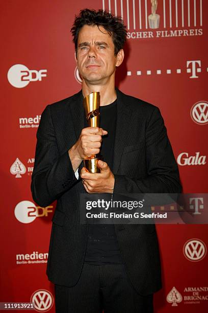 Director Tom Tykwer poses with his award during the 'Lola - German Film Award 2011' at Friedrichstadtpalast on April 8, 2011 in Berlin, Germany.