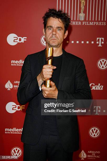 Director Tom Tykwer poses with his award during the 'Lola - German Film Award 2011' at Friedrichstadtpalast on April 8, 2011 in Berlin, Germany.