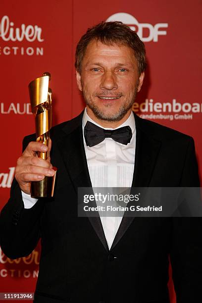 Richy Mueller poses with his award for Best Supporting Actor during the 'Lola - German Film Award 2011' at Friedrichstadtpalast on April 8, 2011 in...