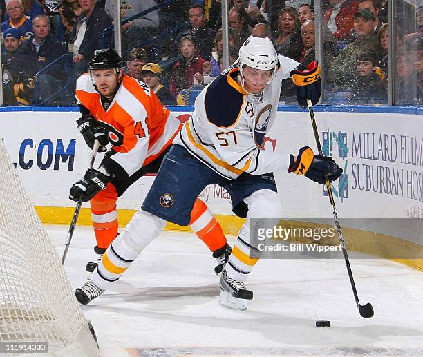 Tyler Myers of the Buffalo Sabres carries the puck behind the net while being trailed by Andrej Meszaros of the Philadelphia Flyers at HSBC Arena on...
