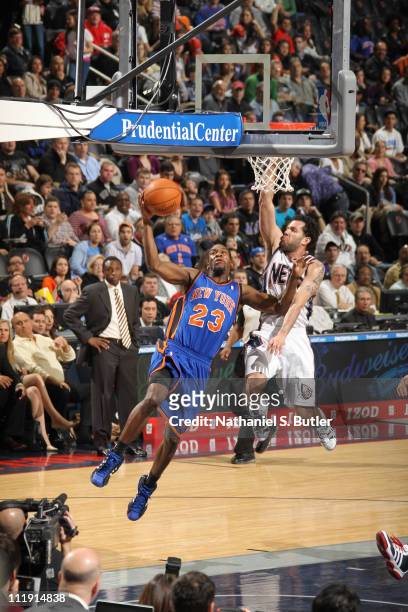 Toney Douglas of the New York Knicks shoots against Jordan Farmar of the New Jersey Nets on April 8, 2011 at Prudential Center in Newark, New Jersey....