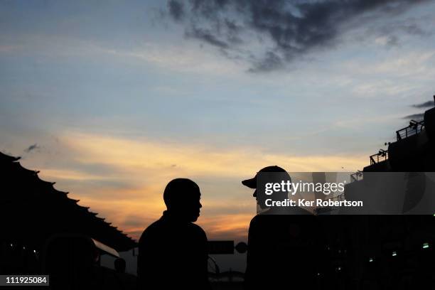 Lewis Hamilton of Great Britain and McLaren and his father Anthony Hamilton walk together at dusk in the pitlane following qualifying for the...